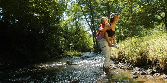 Maman Enfants Sur Le Dos Dans Cours D'eau