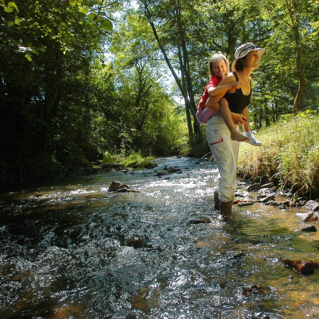 Maman Enfants Sur Le Dos Dans Cours D'eau