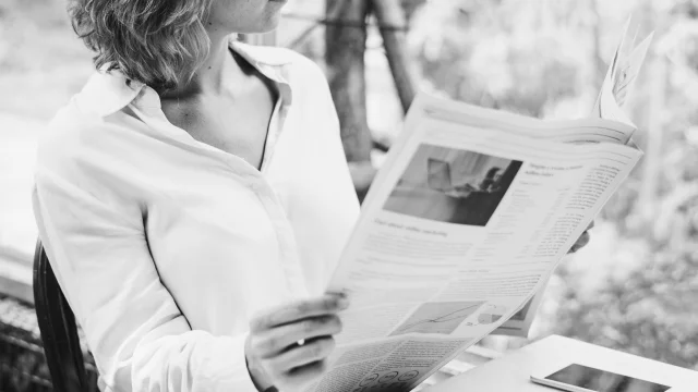 Business woman reading newspaper in the morning